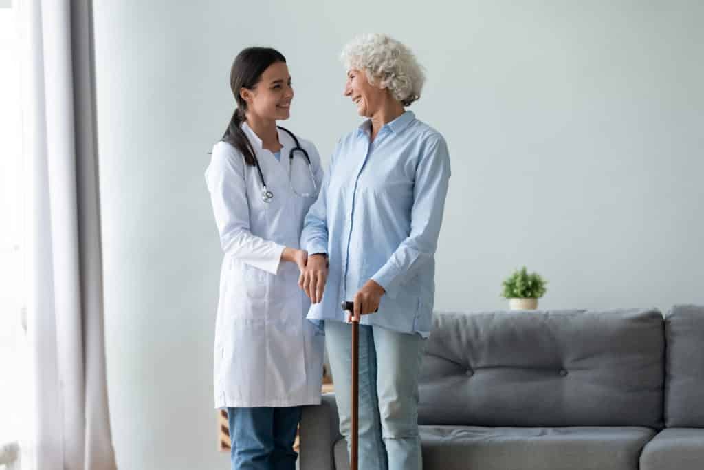 Caring female nurse help senior lady at home
